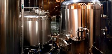 Image shows several large, copper tanks used in brewing. This included CO2 recovery equipment for brewery. 