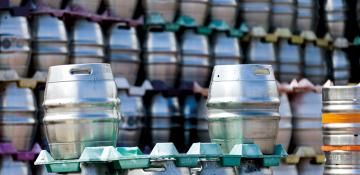 Image shows metal beer casks, using ekegplus for brewers to rent, some in foreground and more stacked in the background